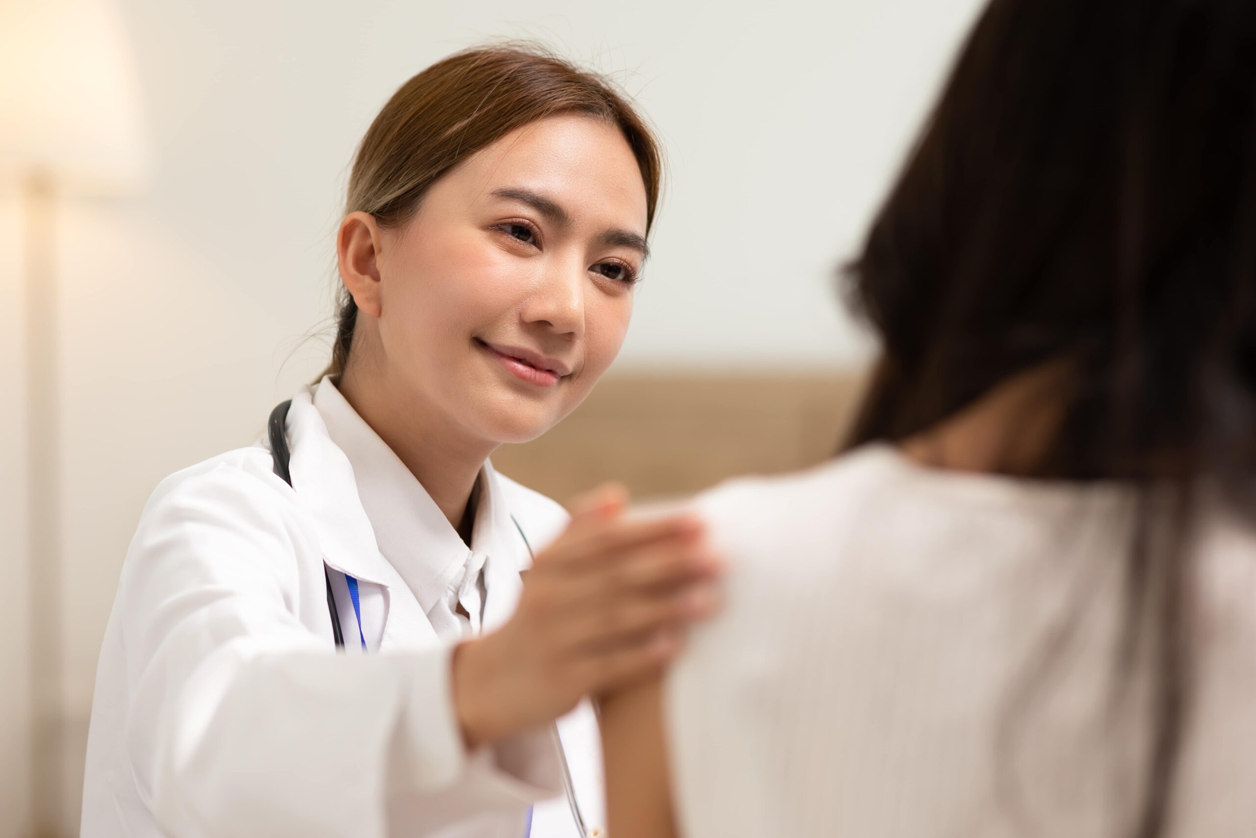 Asian female doctor giving hope and encourage to stressed woman patient