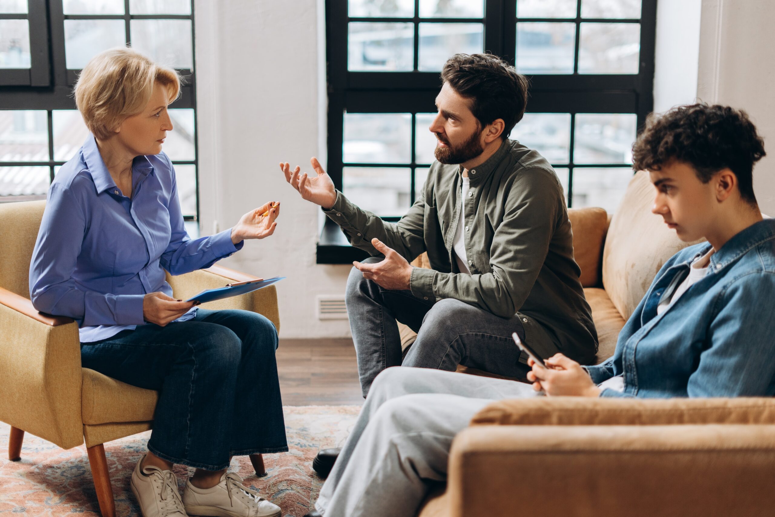 Therapist guiding a family discussion with open body language and calm environment family support and trust rebuilding in addiction recovery Essence Recovery Center